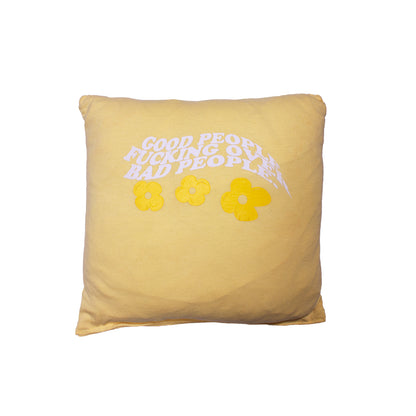 front of a yellow pillow with screen printed graphic that says "Good People Fucking Over Bad People" with yellow flowers