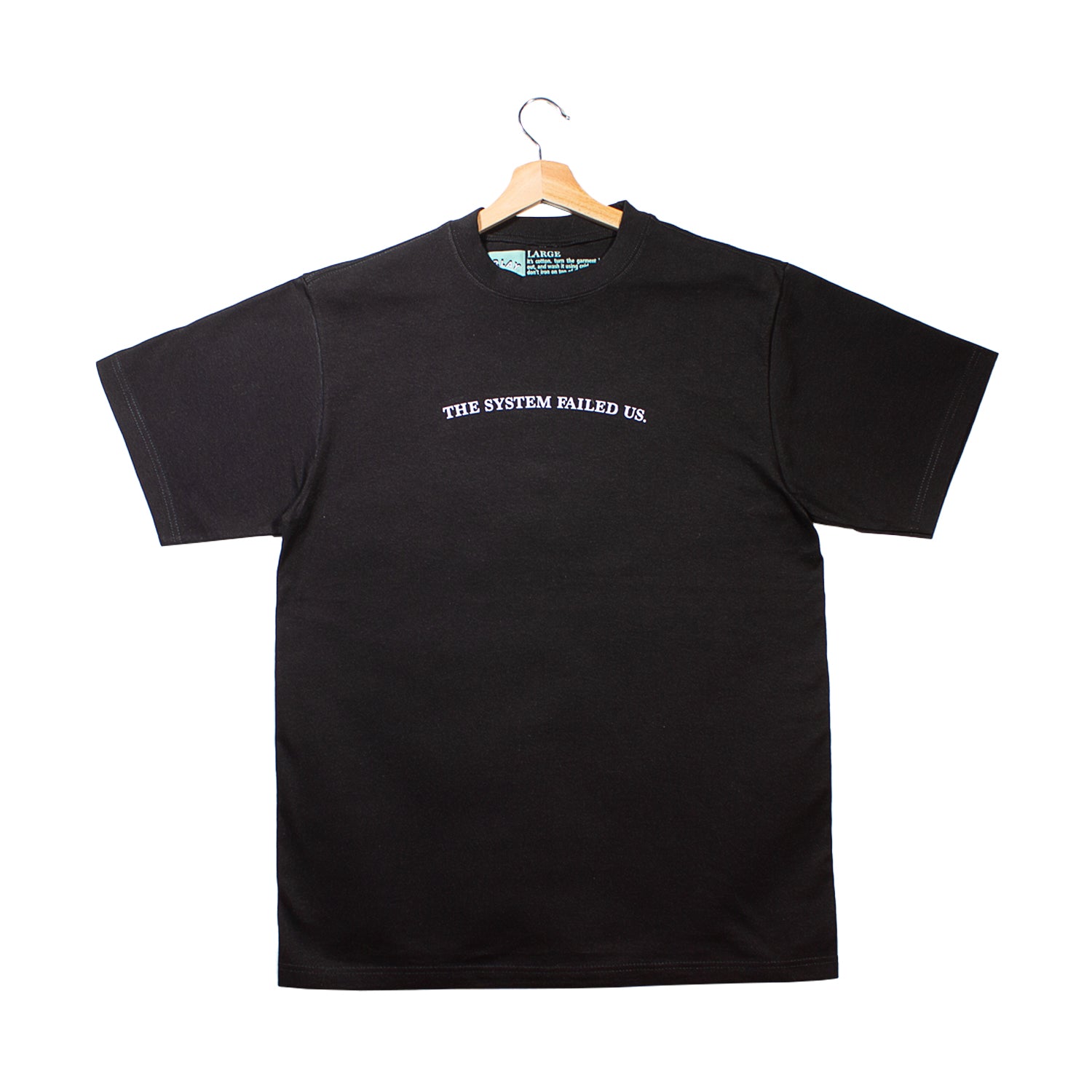 front of a black t-shirt with "the system failed us." graphic