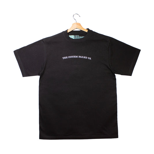 front of a black t-shirt with "the system failed us." graphic
