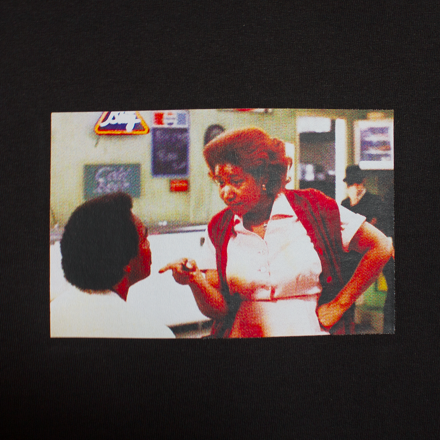 close up of a black t-shirt with a graphic of a photo from a scene of the movie Blue's Brothers showing Aretha Franklin telling her movie husband he better think about the consequences of his actions