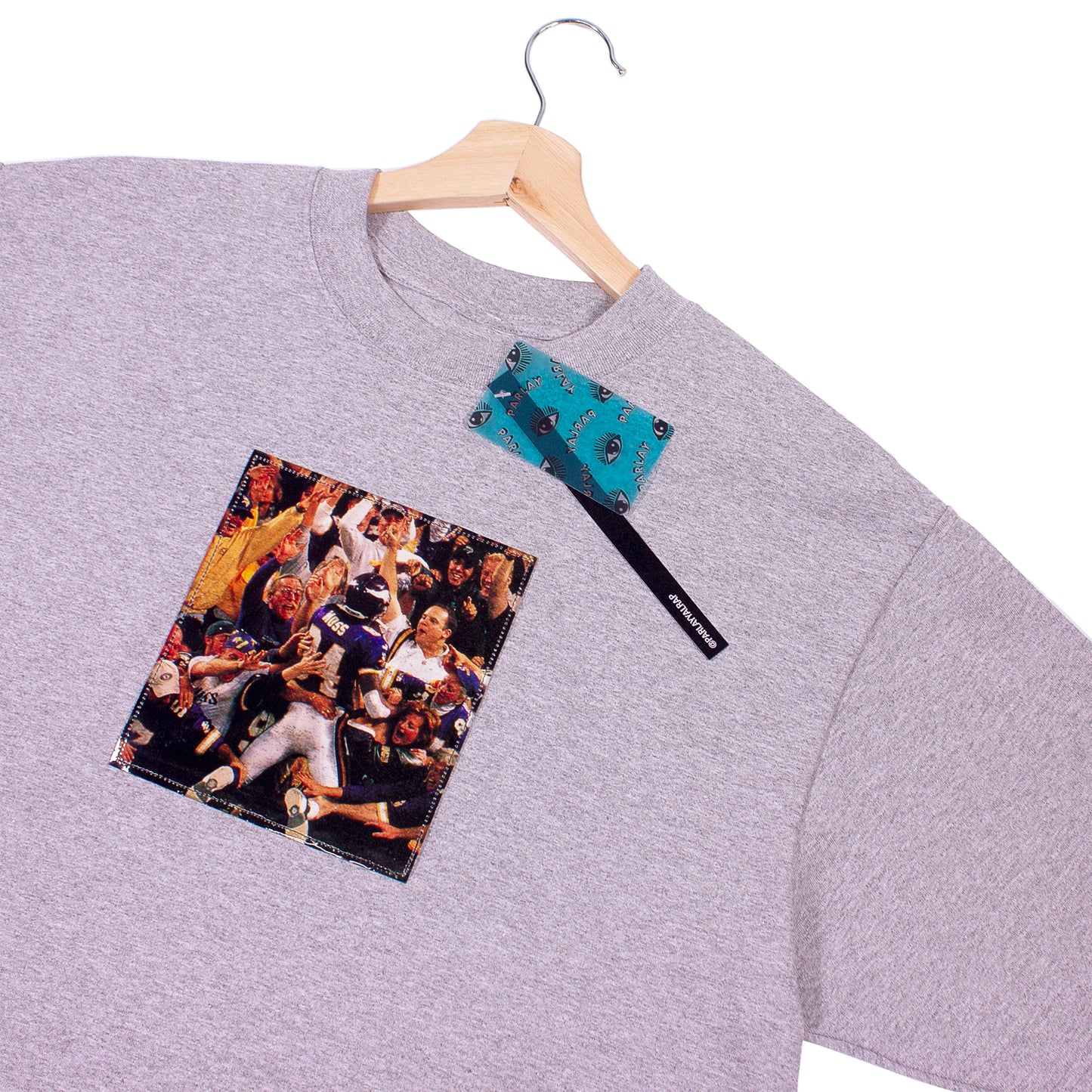 close up of grey t-shirt with a vintage cut out photo of Randy Moss celebrating scoring a touchdown