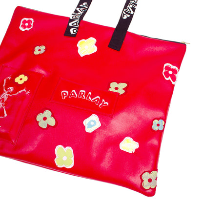 close up of a over the shoulder bag with skeleton embroidered with screen printed flowers 