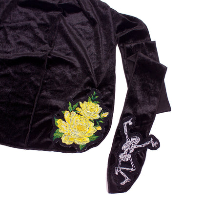 close up photo of a black du-rag with embroidered flower and skeleton
